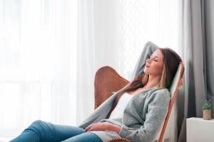 Woman relaxing in a chair with her eyes closed.