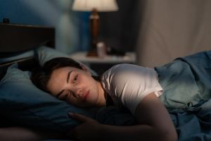 Woman laying in bed awake in the early morning