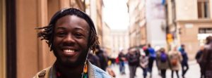 Close up of smiling man's face walking in a crowded city.