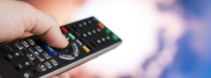 Up close of hand holding a tv remote.