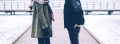 Couples bodies standing across from each other outside.