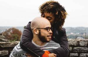 woman kissing man by rocks