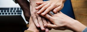 Close up of different peoples hands stacked on top of each other.