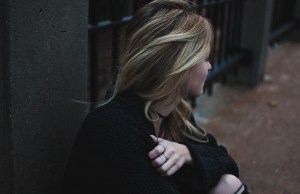 Woman looking away sitting outside.