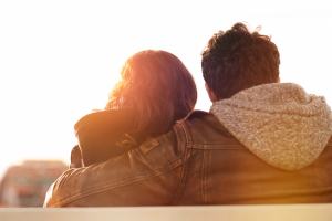 Couple holding each other on a bench.