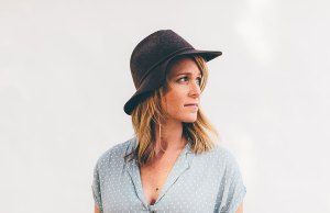 Woman in blue shirt with black hat.