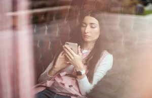 woman sitting down using an iphone