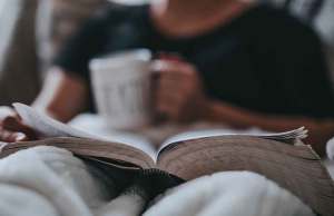 reading in bed with mug