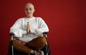 Woman meditating with closed eyes in wheelchair.