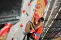 Man in a red shirt climbing a rock wall