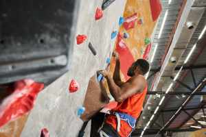 Man in a red shirt climbing a rock wall