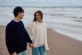 Couple walking on the beach holding hands