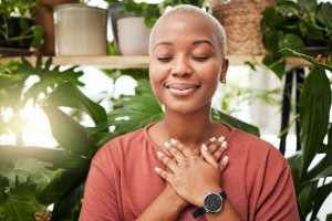 Woman with her hands on her heart surrounded by plants