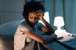 Stressed woman wearing sweats in bed