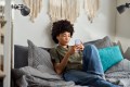 Young woman scrolling on her phone in bed