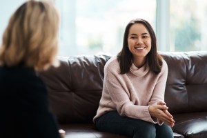 Young woman smiling during a conversation with her therapist during a counseling session